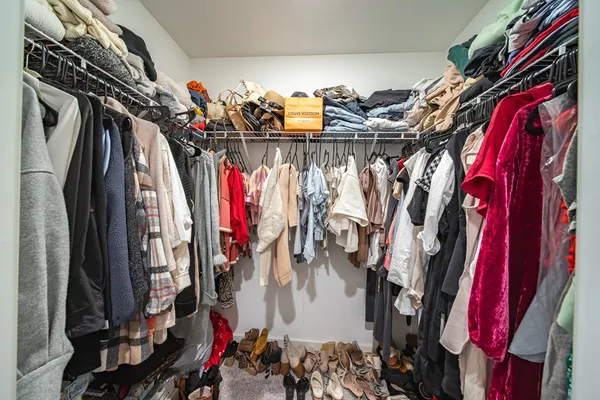a view of walk in closet with clothes