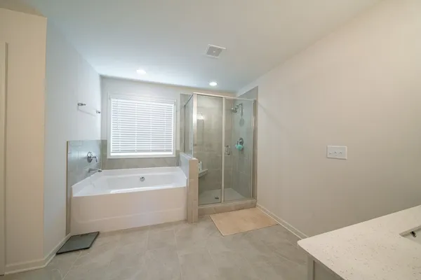 a spacious bathroom with a bathtub sink and mirror