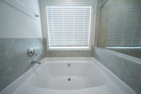 a white bath tub sitting in a bathroom next to a window