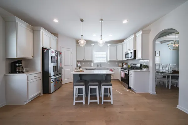 a kitchen with refrigerator a sink and chairs