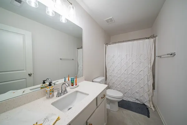 a bathroom with a sink a toilet and shower curtain