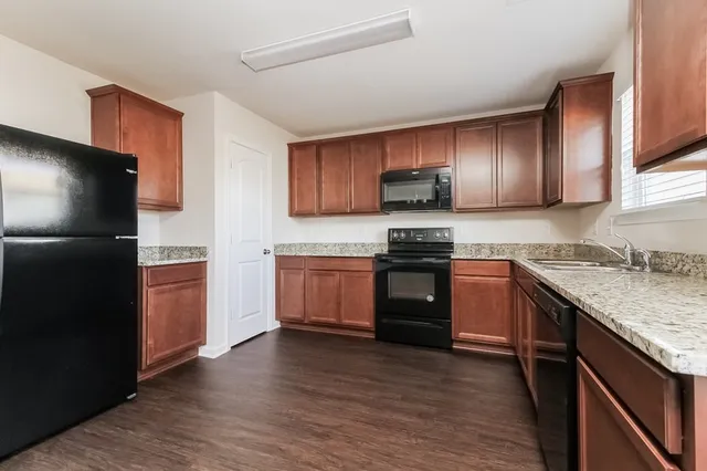 a kitchen with stainless steel appliances granite countertop a refrigerator stove and sink