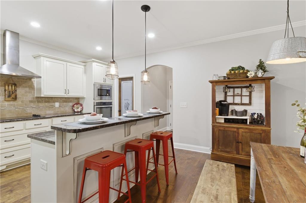 37 Farmstead Way Senoia, GA 30276 - Photo 39 of 121 a kitchen with stainless steel appliances granite countertop a sink a stove and a wooden floors