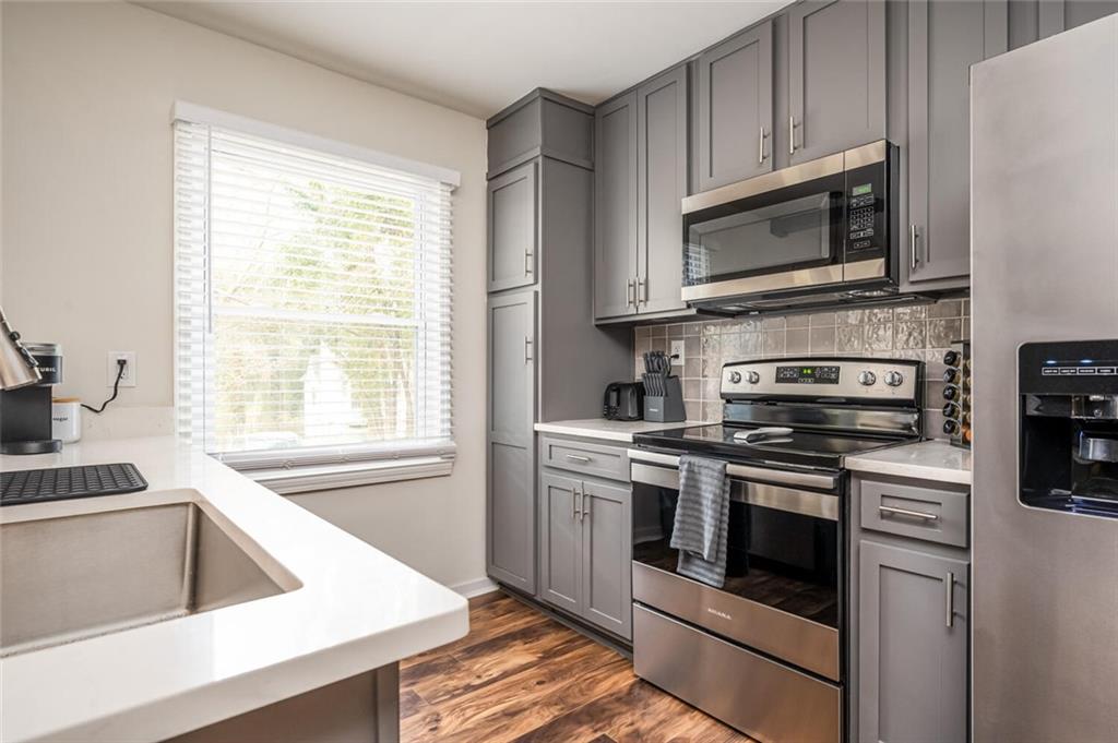 3154 Oakcliff Road Northwest Atlanta, GA 30311 - Photo 11 of 41 a kitchen with stainless steel appliances white cabinets granite counter tops and a window