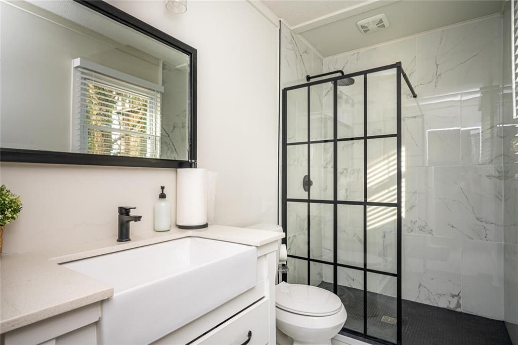 3154 Oakcliff Road Northwest Atlanta, GA 30311 - Photo 17 of 41 a bathroom with a toilet sink vanity and mirror
