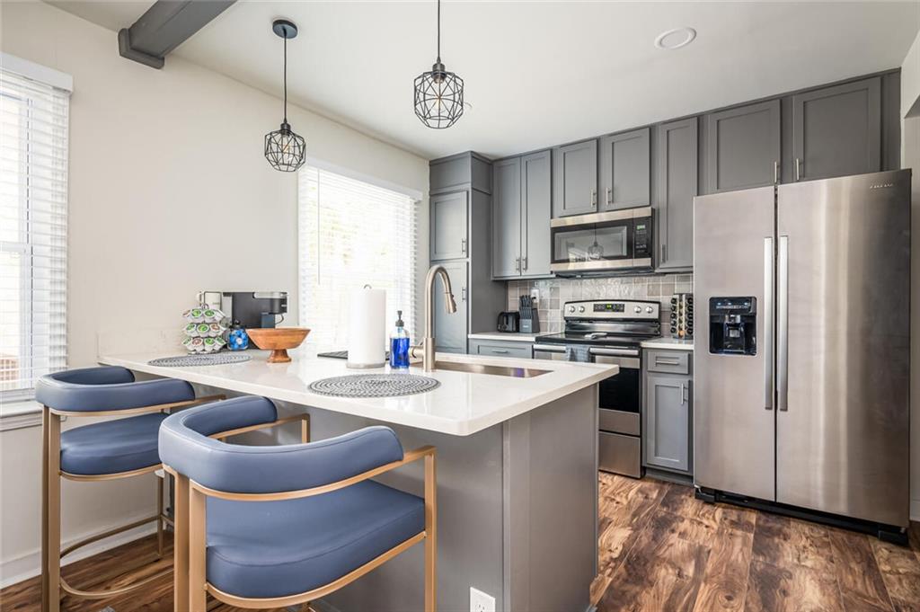 3154 Oakcliff Road Northwest Atlanta, GA 30311 - Photo 2 of 41 a kitchen with stainless steel appliances granite countertop a sink a stove a refrigerator cabinets a dining table and chairs