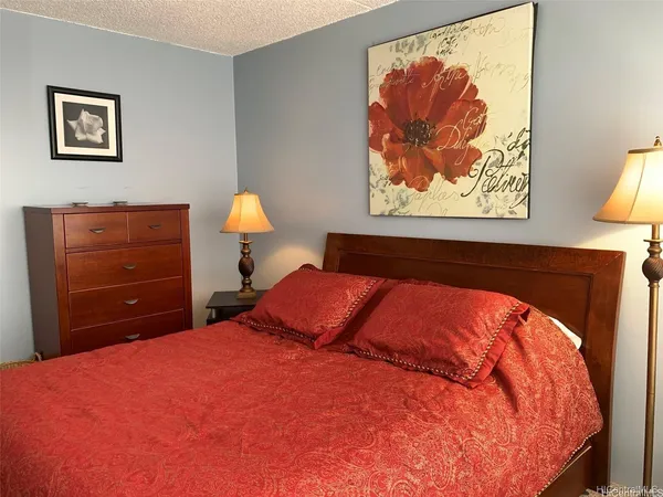 a bedroom with a bed and painting on the wall