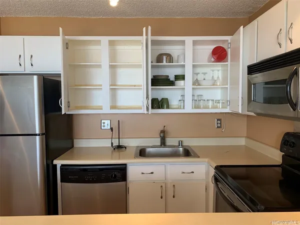 a kitchen with a sink a refrigerator and cabinets