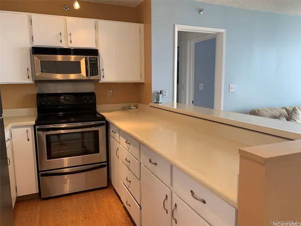 a kitchen with granite countertop white cabinets and stainless steel appliances
