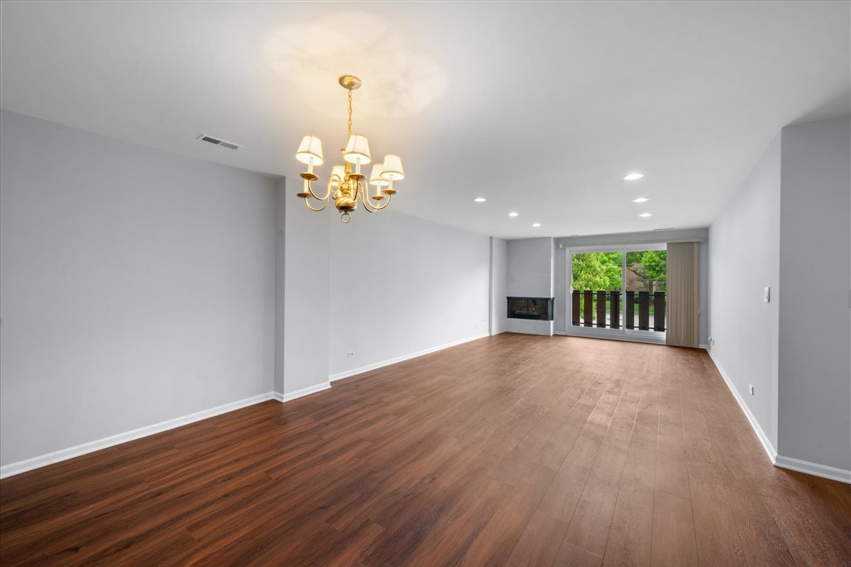 1795 Lake Cook Road, Unit 107 Highland Park, IL 60035 - Photo 6 of 26 a view of an empty room with wooden floor and a window