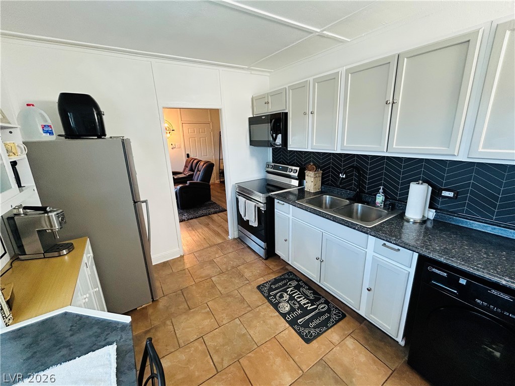 116 West Basic Road Henderson, NV 89015 - Photo 31 of 39 A compact culinary space features dark herringbone tile backsplash and practical appliances.