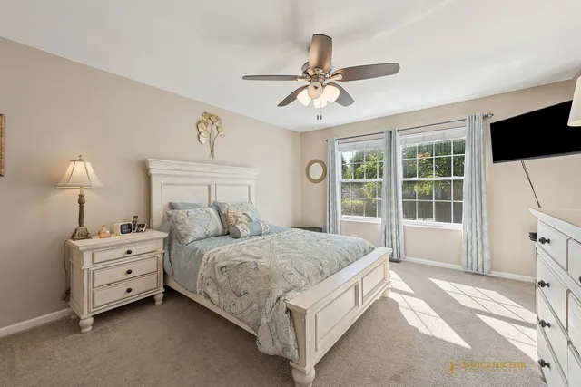 a spacious bedroom with a bed chandelier and a window