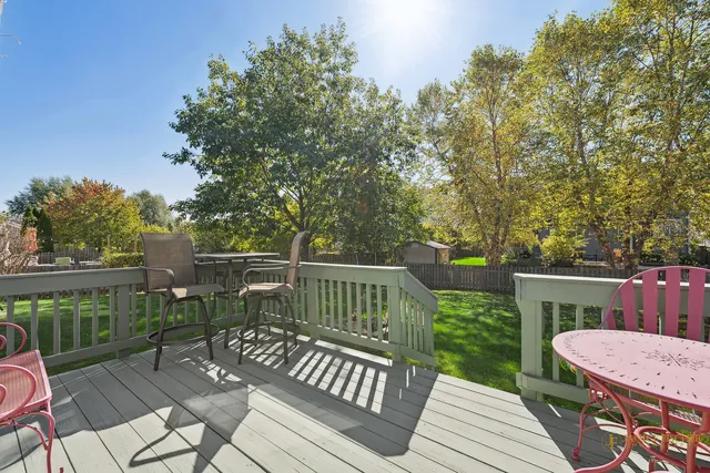 a view of a deck with furniture and trees around