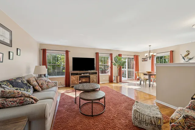 a living room with furniture a flat screen tv and a large window