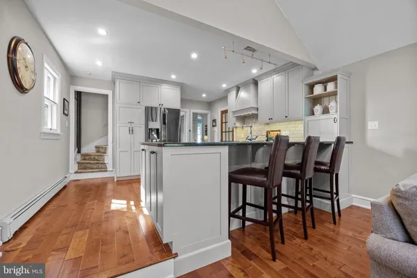 a kitchen with stainless steel appliances a dining table chairs microwave and sink