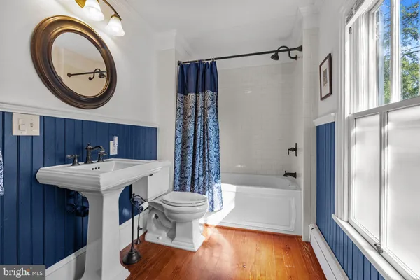 a bathroom with a sink a toilet and a large mirror