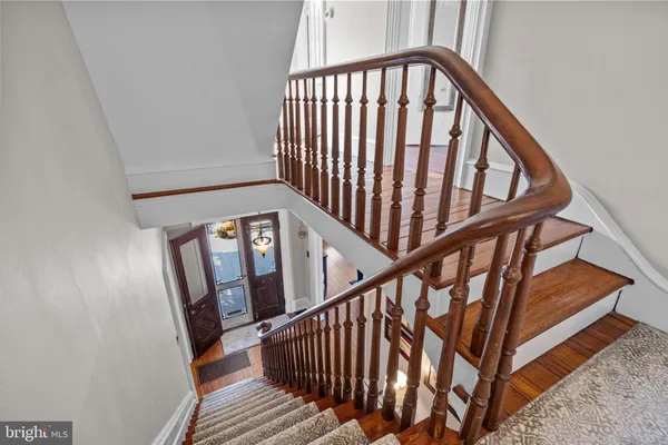 a view of staircase with wooden floor and white walls