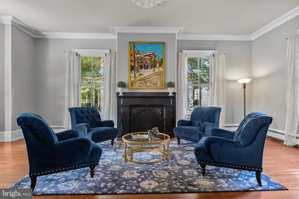 a living room with furniture a rug a window and a fireplace