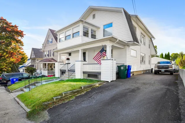 a car parked in front of a white house