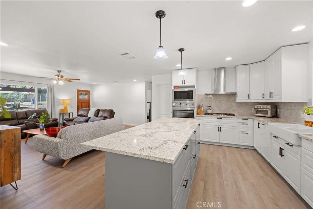 3855 Acton Avenue Acton, CA 93510 - Photo 3 of 21 a large kitchen with kitchen island a large counter top space a sink stainless steel appliances and cabinets