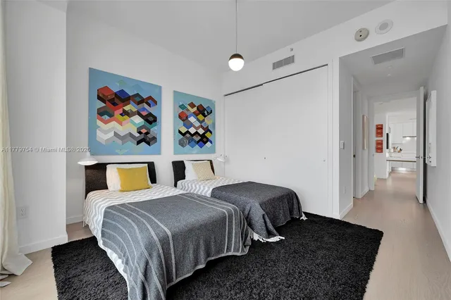 a bedroom with a bed and painting on the wall