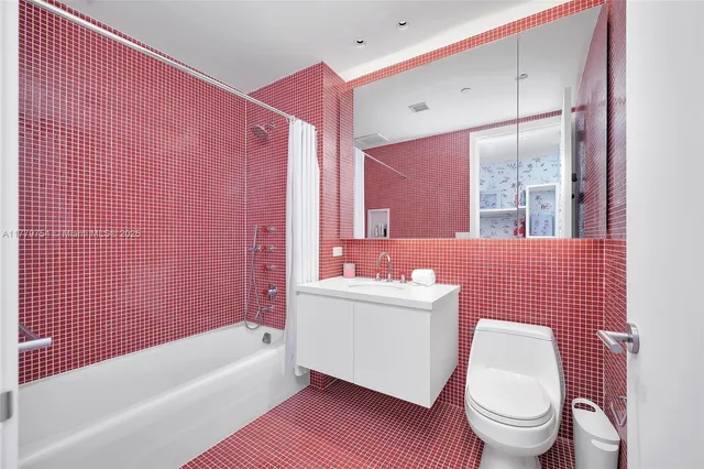 a bathroom with a sink a toilet a mirror and shower