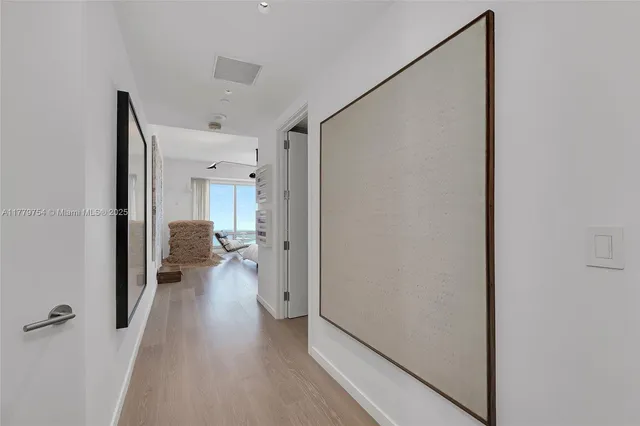a hallway with wooden floor closet and a bathroom