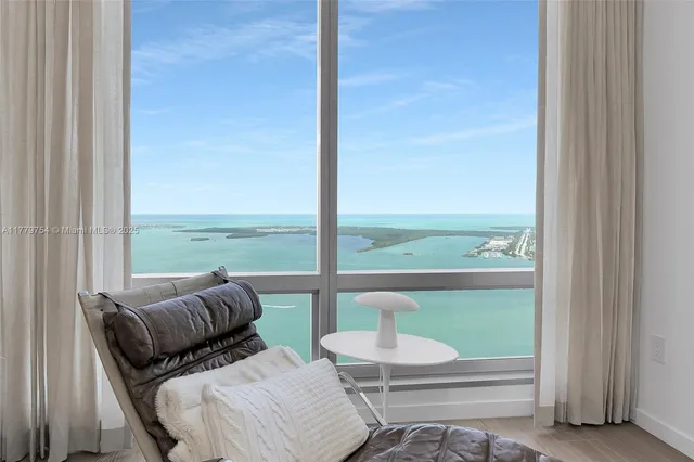 a living room with furniture and a floor to ceiling window