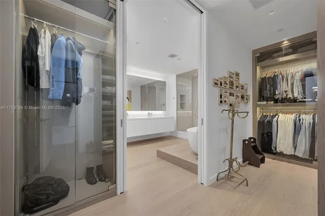 a view of a hallway with bathroom and glass door shower