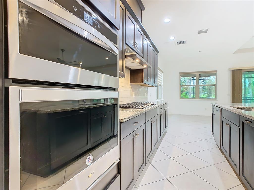 8325 Topsail Place Winter Garden, FL 34787 - Photo 13 of 74 a kitchen with stainless steel appliances granite countertop a stove and a sink