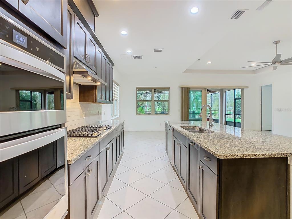 8325 Topsail Place Winter Garden, FL 34787 - Photo 14 of 74 a kitchen with stainless steel appliances granite countertop a stove and a sink