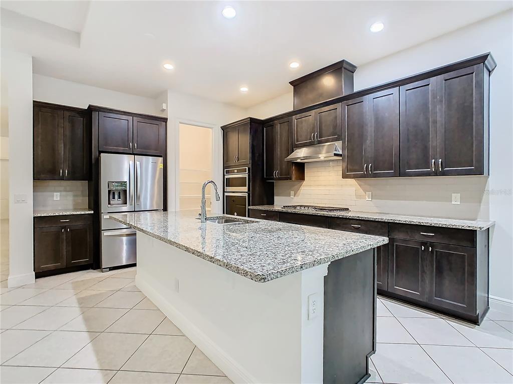 8325 Topsail Place Winter Garden, FL 34787 - Photo 19 of 74 a kitchen with stainless steel appliances granite countertop a sink stove and refrigerator