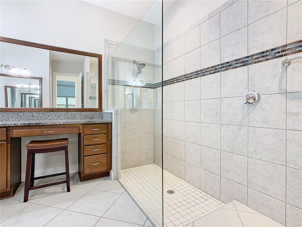 8325 Topsail Place Winter Garden, FL 34787 - Photo 31 of 74 a bathroom with a granite countertop sink a mirror and a shower