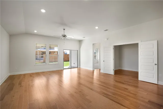 a view of an empty room with wooden floor