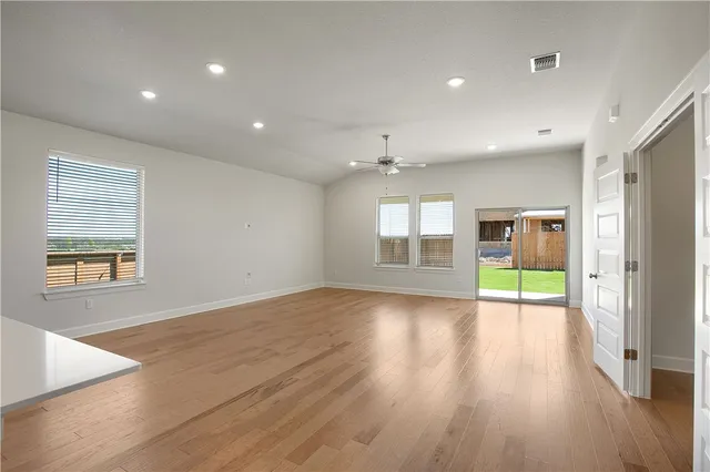an empty room with wooden floor and a window