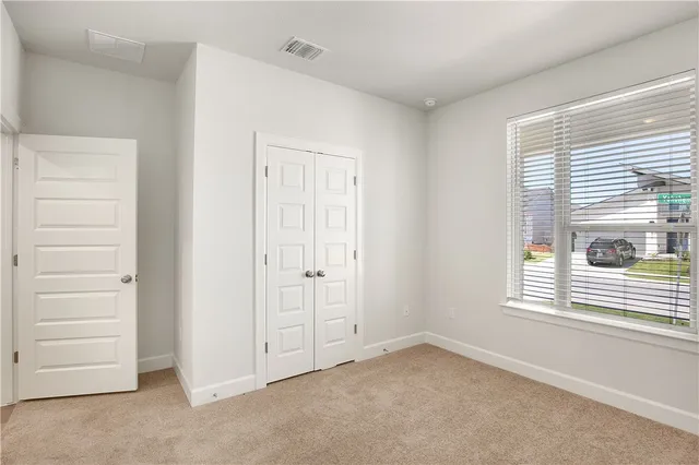 an empty room with a window and a ceiling fan