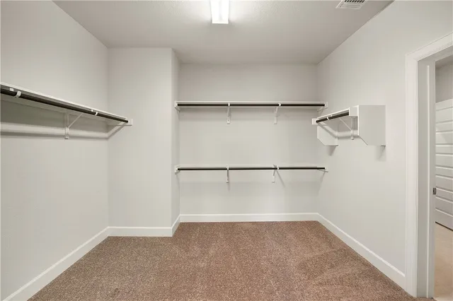 a view of walk in closet with empty racks