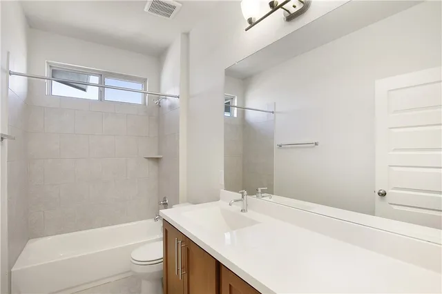 a bathroom with a sink toilet vanity and shower