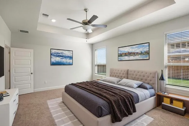 a bedroom with a large bed and a chandelier