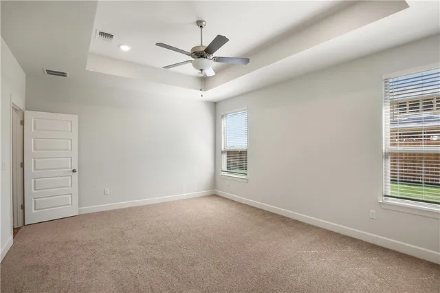 an empty room with windows and fan