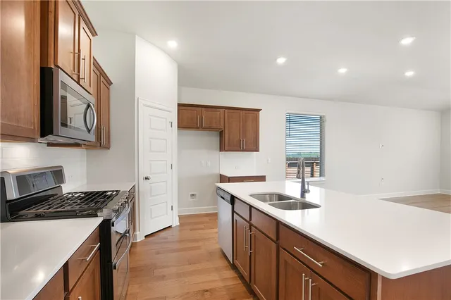 a kitchen with stainless steel appliances granite countertop a sink stove and cabinets