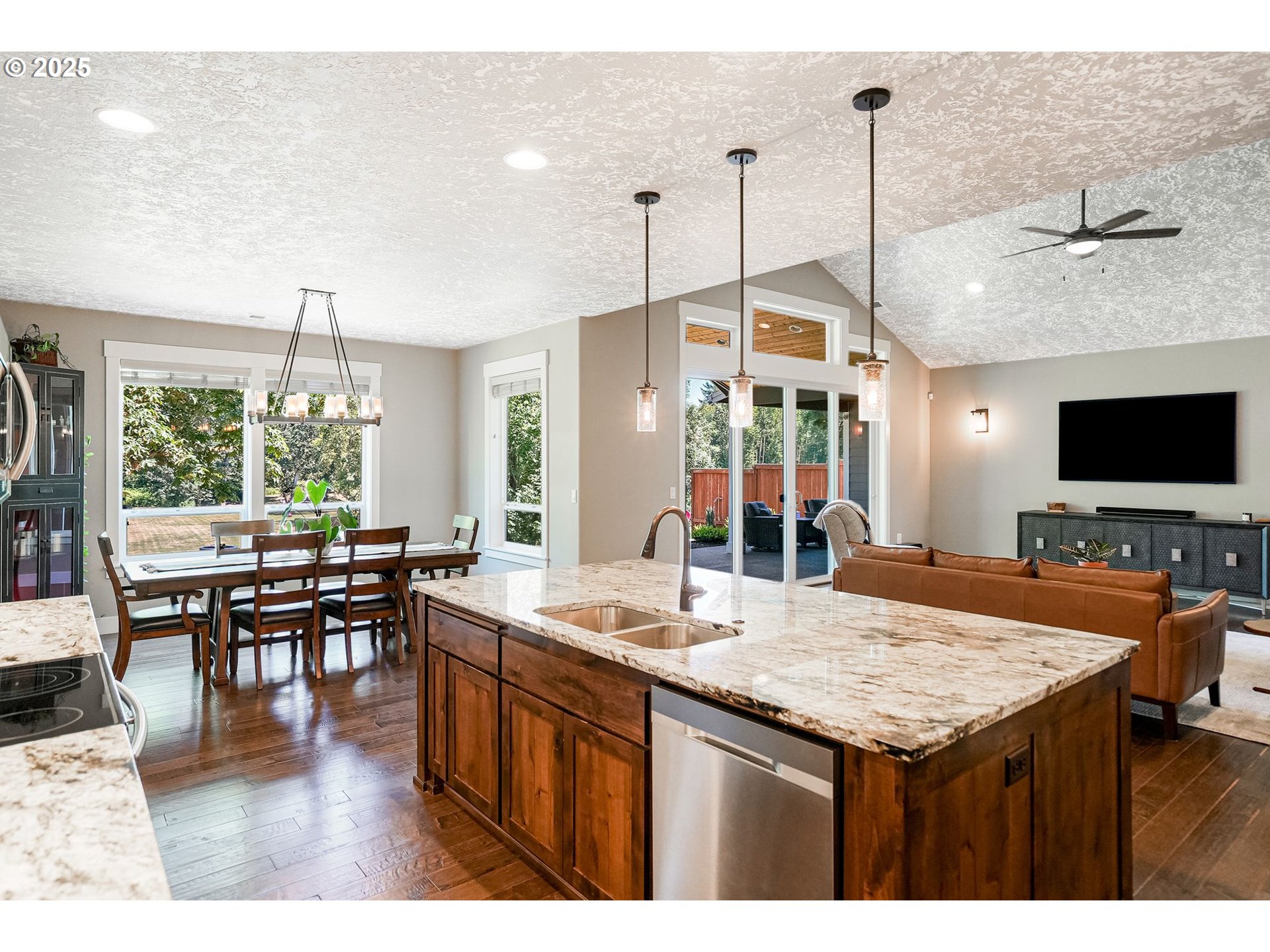 6300 Corvallis Road Independence, OR 97351 - Photo 16 of 48 a kitchen island with granite countertop a stove a sink a dining table and chairs with wooden floor