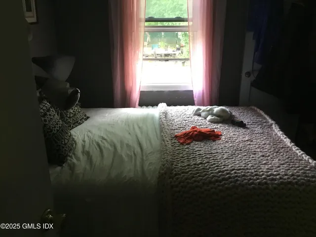 a bedroom with a bed next to a window