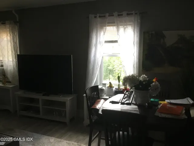 a living room with furniture a flat screen tv and a window