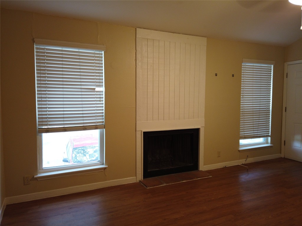 1000 West 26th Street, Unit 209 Austin, TX 78705 - Photo 3 of 20 an empty room with wooden floor fireplace and windows