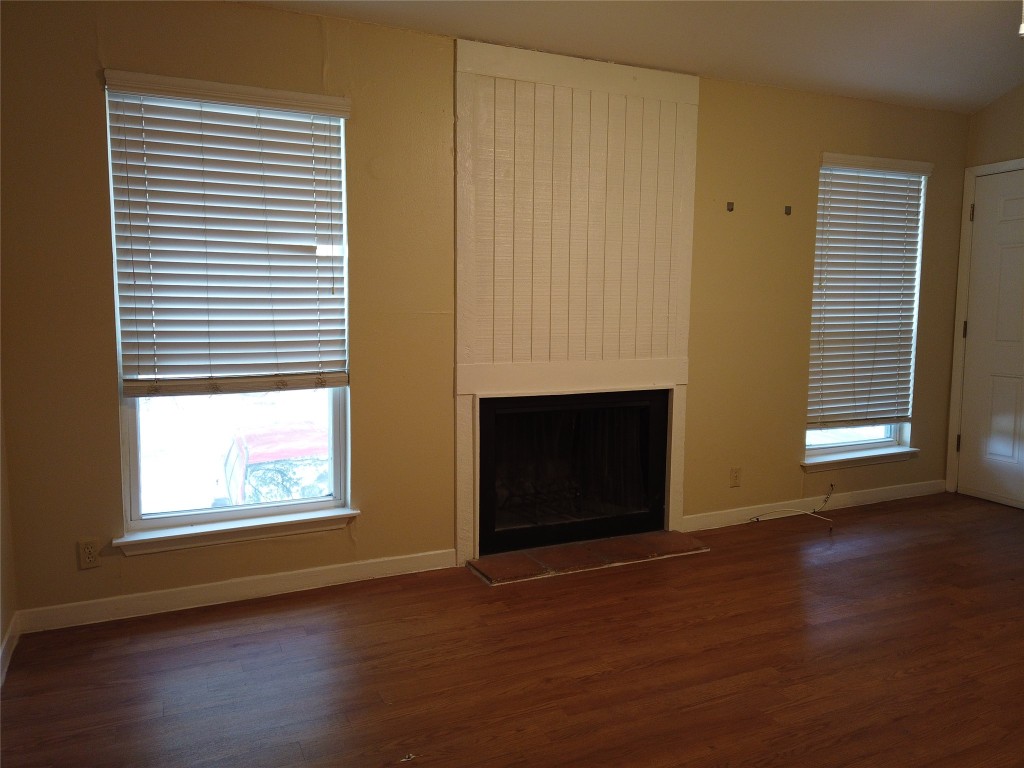1000 West 26th Street, Unit 209 Austin, TX 78705 - Photo 4 of 20 an empty room with wooden floor fireplace and windows