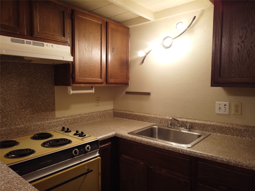 1000 West 26th Street, Unit 209 Austin, TX 78705 - Photo 9 of 20 a kitchen with a sink a stove and cabinets