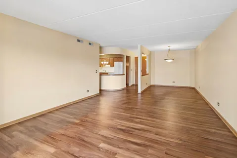 a view of a room with wooden floor closet and windows