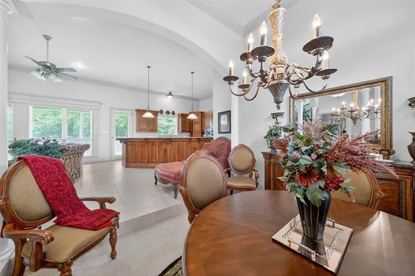 a room with chandelier fan and wooden floor