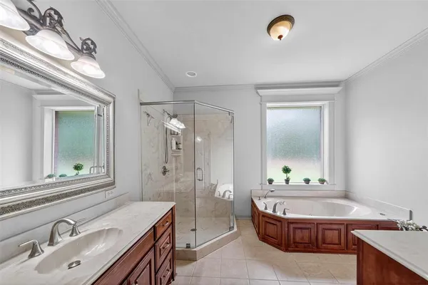 a bathroom with a granite countertop double vanity sink a mirror and a bathtub